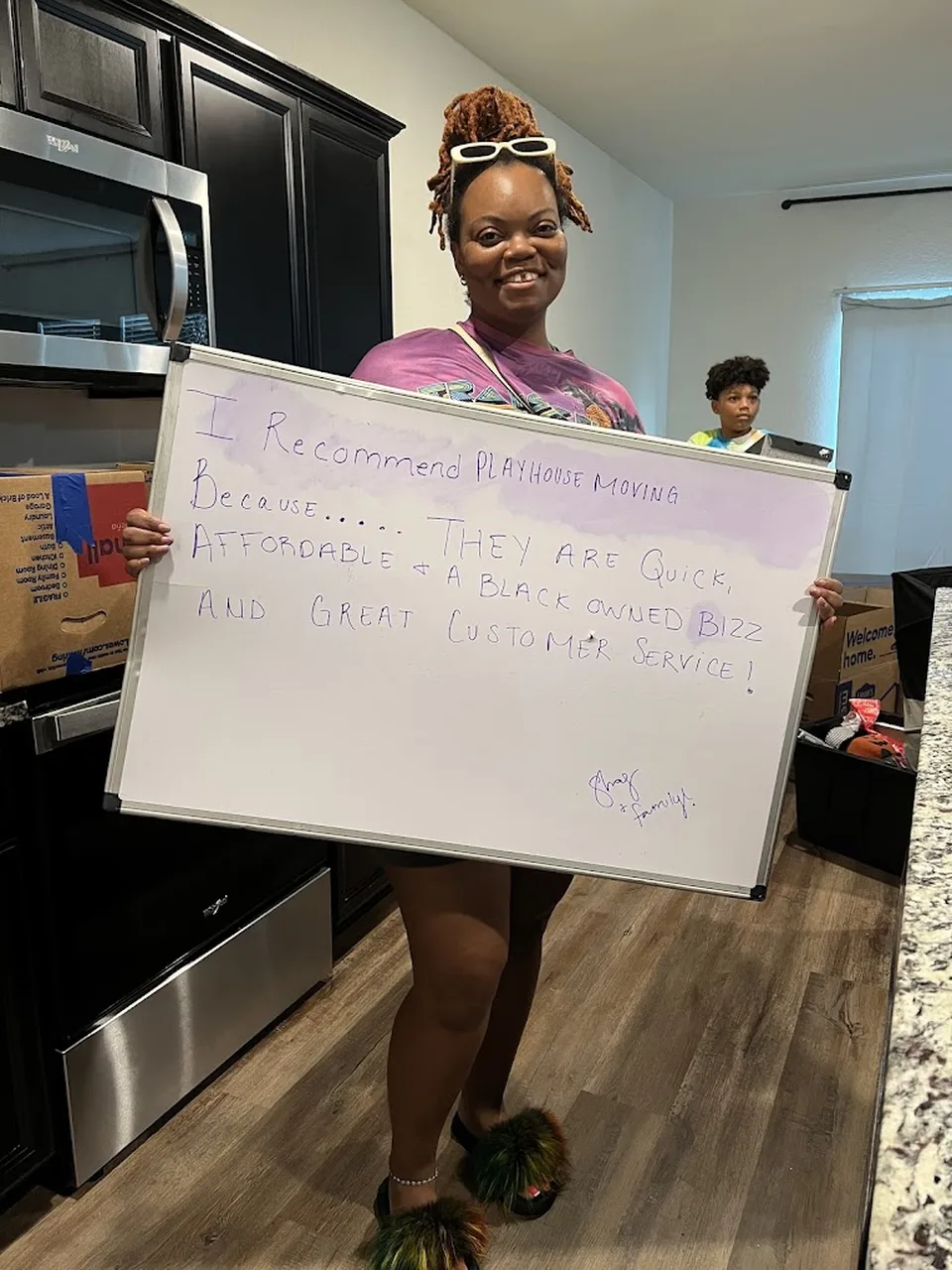 Customer holding a Playhouse Moving recommendation board praising quick, affordable service and great customer service